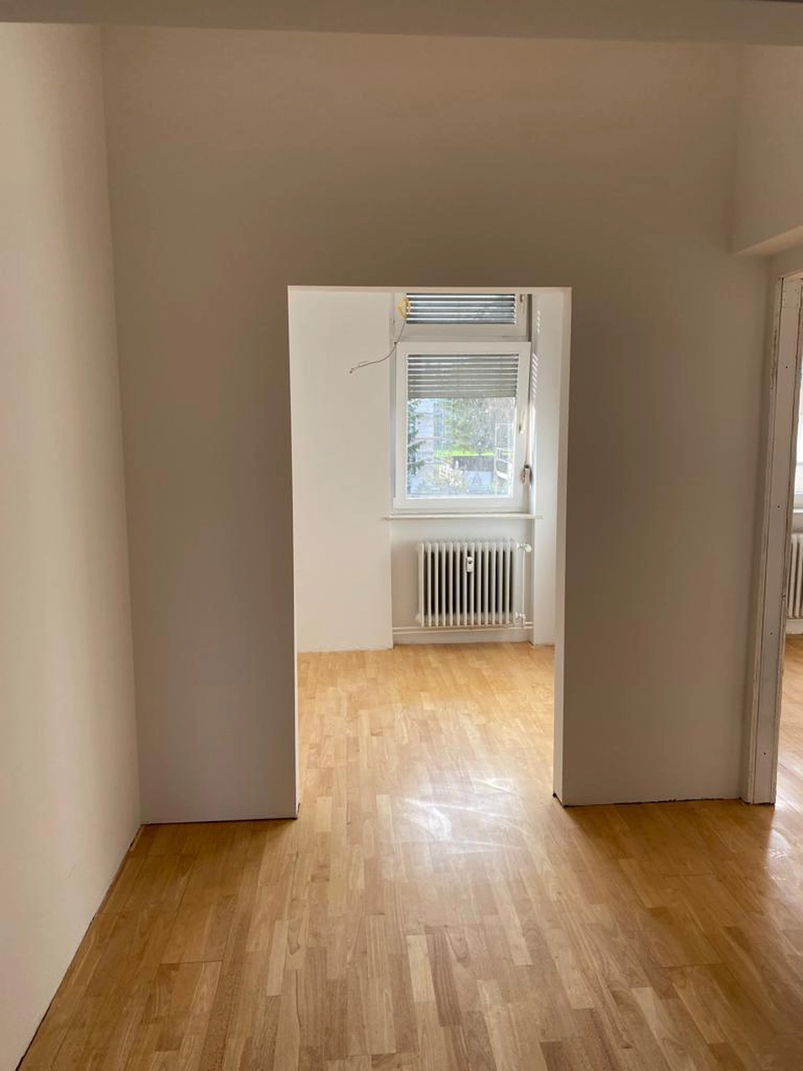 Bauabdichtungen- Bausanierungen Tiriakidis -  Komplette Renovierungsdienstleistungen – 2 Zimmer mit Holzboden und Tür dazwischen